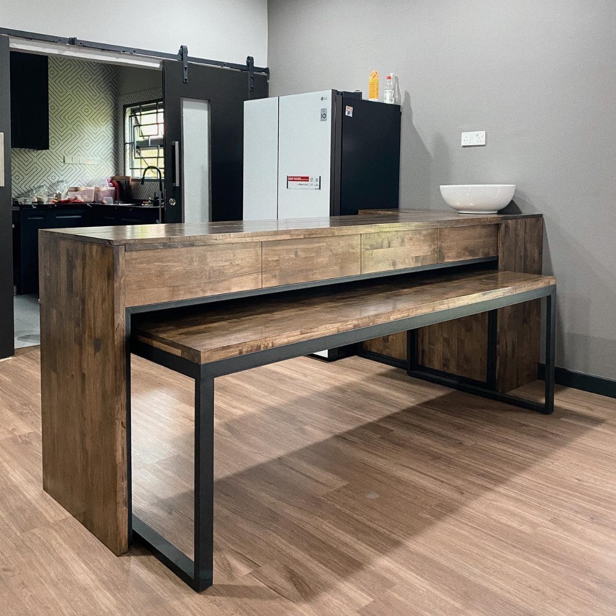 Rustic wooden freestanding table and matching bench with black metal legs on wood floors.
